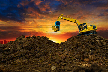 Crawler Excavator is digging in the construction site and pipeline  with sunset backgrounds. - obrazy, fototapety, plakaty