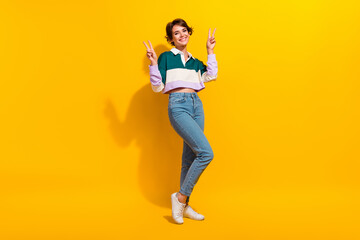 Fototapeta na wymiar Full length photo of friendly positive lady dressed polo shirt showing two v-signs isolated yellow color background