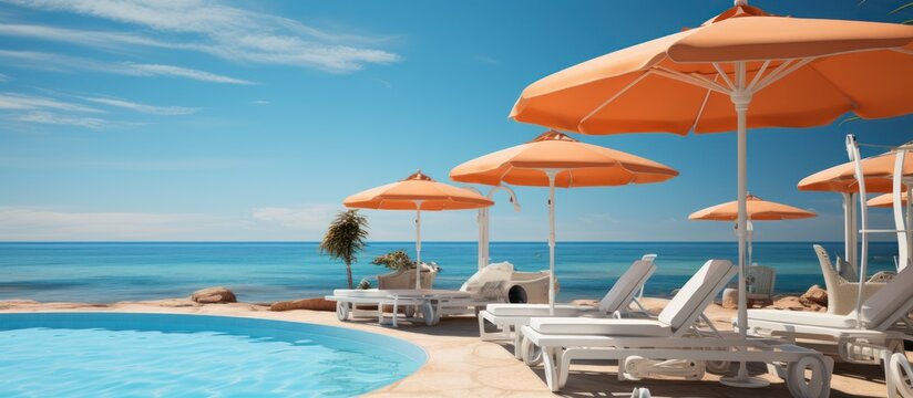 swimming pool and loungers umbrellas near beach