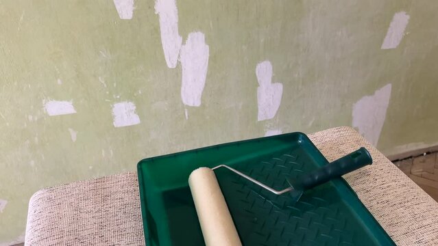 Paint roller in container room. Painting the walls in a room with a paint roller. Roller Painting Container and the Painting Roller for Paint, construction works.