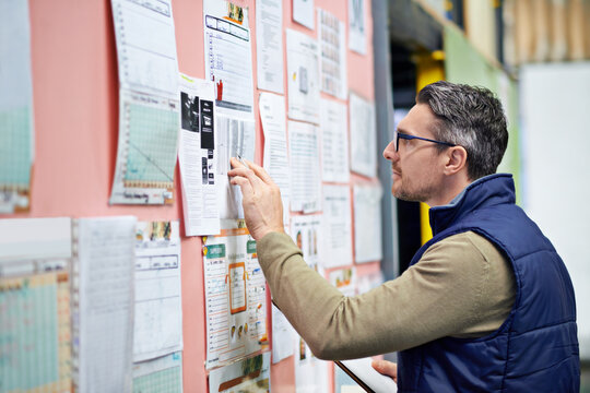 Warehouse, man and board in business for planning or operations, shipping or logistics or management. Male person, clipboard and schedule in workplace for review or job, inventory or supply and check