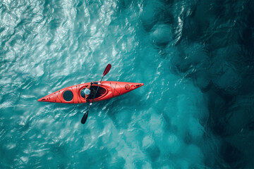 Aerial view of a kayak in the blue water. Kayaking top view. Kayaker in the red kayak paddling on the sea