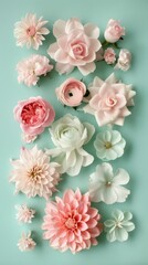 A creative, colorful display of various handcrafted paper flowers neatly arranged on a soothing mint background