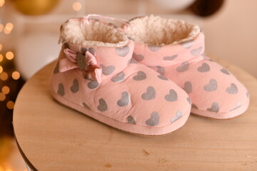 Cozy pink slippers with heart patterns and soft fur lining, perfect for cold weather.