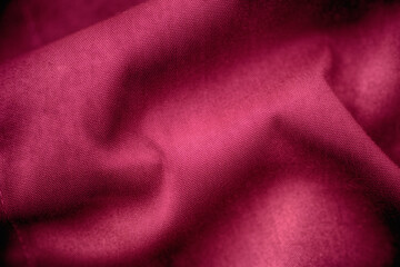 A crumpled magenta fabric texture background. Close up.
