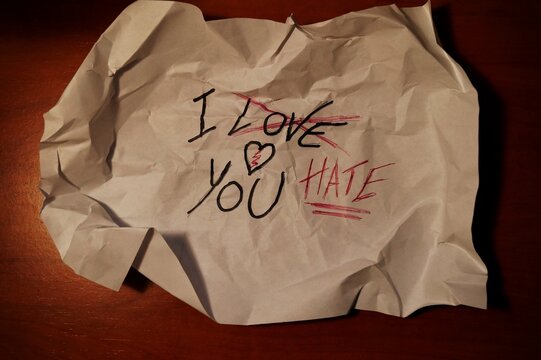 foglio di carta stropicciato con la scritta, ti amo, cancellata e rimpiazzata da, ti odio, concetto tra amore odio