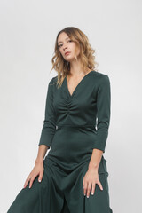 Serie of studio photos of young female model wearing green dress