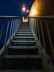 Low-angle shot of a staircase illuminated in the evening, with a dark night sky overhead