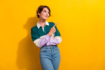 Photo of cute dreamy lady dressed polo shirt looking pointing finger empty space isolated yellow color background - obrazy, fototapety, plakaty