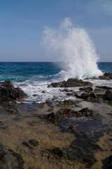 onda che si schianta sulle rocce della costa, scogli, con schizzi, spruzzi d'acqua che si proiettano per vari metri,dati dalla forza dell'impatto, onde dell'oceano atlantico,scattate a fuerteventura
