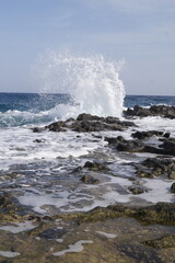 onda che si schianta sulle rocce della costa, scogli, con schizzi, spruzzi d'acqua che si proiettano per vari metri,dati dalla forza dell'impatto, onde dell'oceano atlantico,scattate a fuerteventura