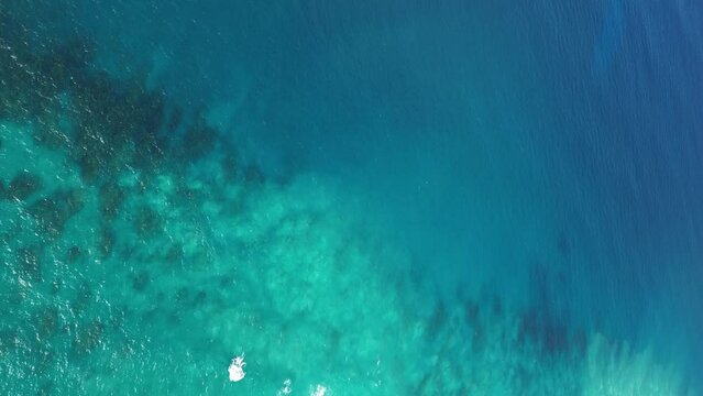 Ideal turquoise sea background. Aerial view of perfect teal blue waters of Pacific ocean. Top down drone shot best snorkeling site on Hawaii islands with seen through coral reefs and marine wild life.
