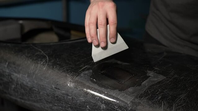 a person doing manual work. close-up of a canoe. Slow-motion video. working with fiberglass. High quality video in 4K format.