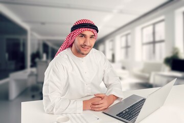 A saudi character man at the desk work on laptop