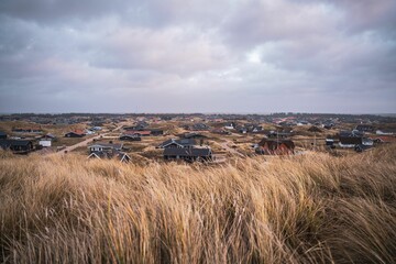 Scenic view of rural houses on the Bjerregard beach on a cloudy day in Hvide Sande, Denmark
