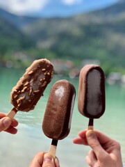 three people holding chocolate ice cream
