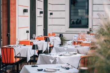 Seating area of a restaurant, with tables and chairs arranged in a pleasant outdoor setting - obrazy, fototapety, plakaty