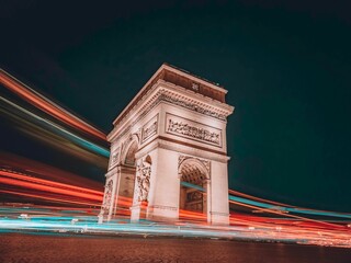 Long exposure nighttime photo of Arc de Triomphe on Champs Elysees avenue, Paris, France