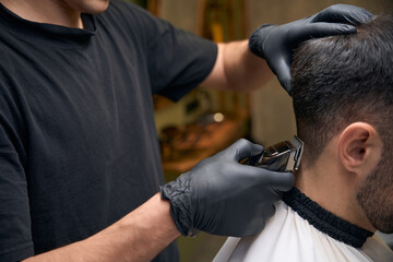Man hairdresser doing haircut for customer