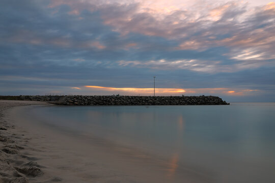 Long exposure photograph at sunset of the ocean and rock wall groyne at Cottesloe Beach, Perth, Western Australia