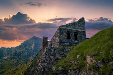 Old building on a rocky cliff at sunset