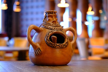Traditional clay jug with intricate patterns and a hole. Used for storing spice.