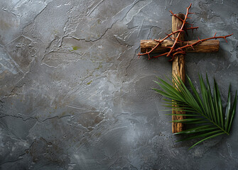 Easter wooden cross and crown of thorns and palm branch on gray background with copyspace