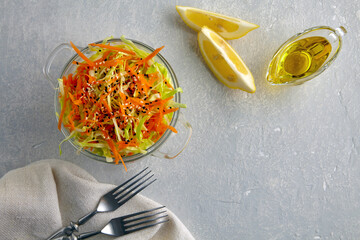 Vegetarian healthy salad of raw vegetables cabbage and carrots with sesame seeds, dressed with olive oil and lemon juice