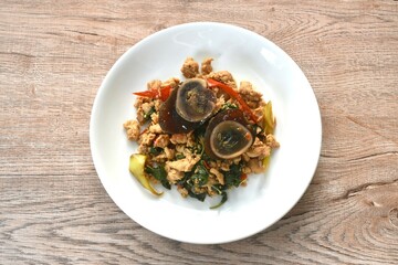 slice boiled  black preserved egg dressing spicy fried chop chicken meat and basil leaf on plate