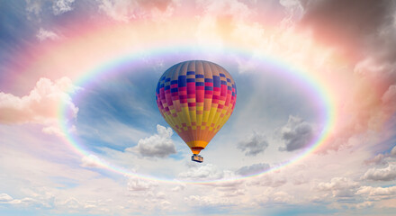 Colorful hot air balloon flying under storm clouds with rounded rainbow