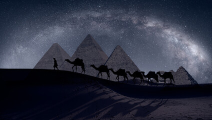 Camel caravan in front of the Great pyramid of Giza complex - The Milky Way rises over the Pyramids...