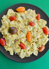 Plate of honey mustard pasta salad with a medley of tomatoes