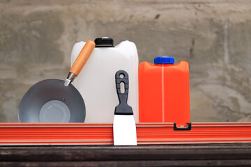Construction or plastering ladle, a spatula, a construction level and a container for primer....