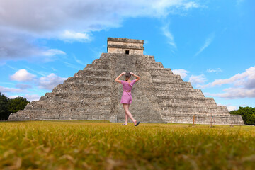 Young girl is standing and taking photos The pyramid of Kukulcan in the Mexican city of Chichen Itza in  the background - Mayan pyramids in Yucatan, Mexico
