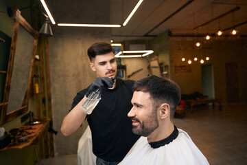 Hairdresser splashes water on the client's hair