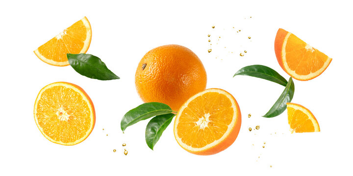 Fresh orange fruit whole and slices with leaves falling flying isolated on white