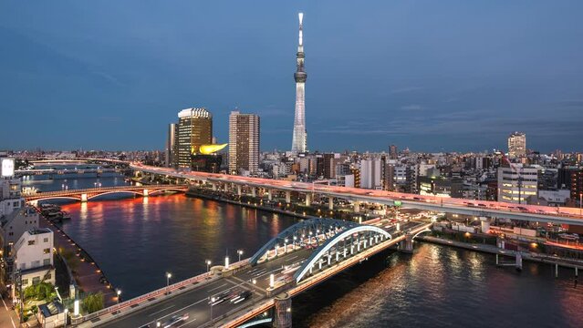 Dusk to night timelapse of Sumida River and Tokyo skyline in Tokyo, Japan, zoom out. 