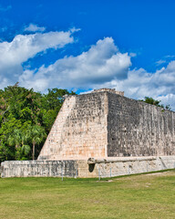 Fototapeta na wymiar Chichén-Itzá, Yucatan Mexico - December 28 2021: Tourists walk near the Mayan pyramids in Chichen Itza. This was during the Covid 19 pandemic on a hot sunny summers day.