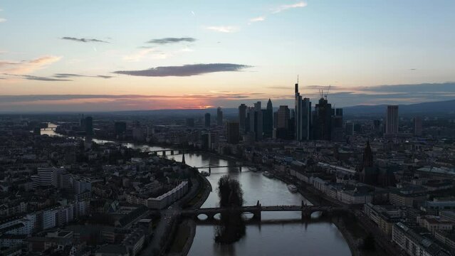 Time lapse drone footage of the Frankfurt skyline and the Main tributary against dusk sky, Germany