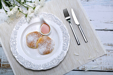 Homemade pancake with icing on top for breakfast it setting on the white dish, the white napery and...