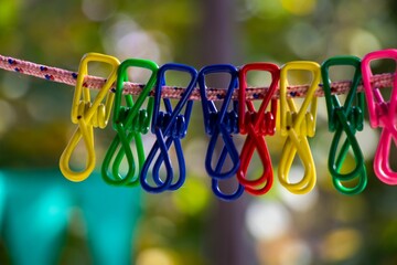 Closeup shot of colorful plastic clothespins hanging from a clothesline
