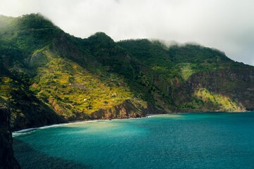Tranquil scenery of a beautiful coastline surrounded by green hills
