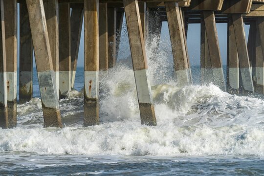 Waves crash against pier foundation in windy weather