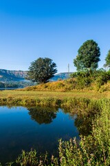 Fototapeta na wymiar Beautiful reflection of a landscape of trees, hills, and water at Arthur Lake in Bhandardara, India