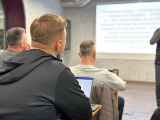 The process of training young businessmen. Students sit in class and listen to the teacher. Students with computers at desks in class, background blurred. Lviv, UBTS Seminary, November 7, 2023