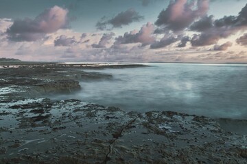 Tranquil beach scene featuring a tranquil ocean and a beautiful sky in hues of pink, Isle of wight - obrazy, fototapety, plakaty