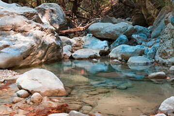 Tranquil outdoor scene of a body of water with colorful rocks on the shoreline