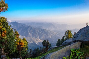 Scenic view of a mountain range covered with greenery at sunrise