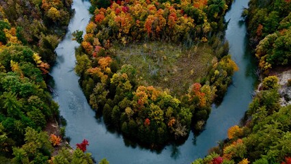 Aerial view of a lake with patches of bright colorful autumn trees in Greenwood