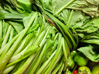 mustard greens and several large chilies in the basket